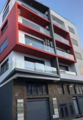 a tall building with red and white at Appartement Vue Mer in Mindelo