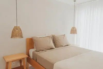 a bedroom with a bed with two pillows and a table at Laginha Apartment in Mindelo