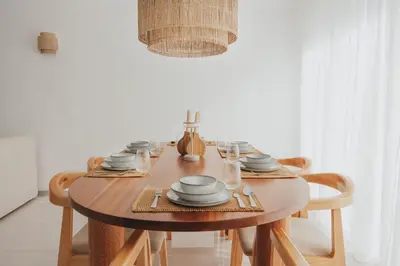 a wooden table with chairs and plates on it at Laginha Apartment in Mindelo