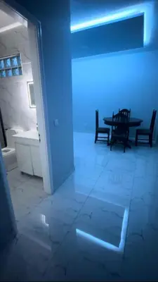 a blue light in a room with a table and chairs at Apartamento T2 mobiliado in Mindelo