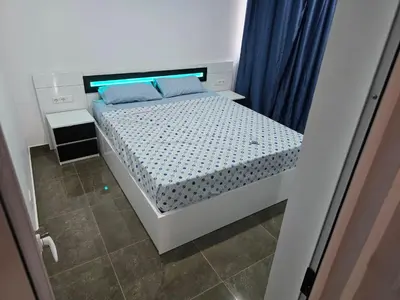 a small bedroom with a bed with blue pillows at Apartamento Inteiro Porto Novo Abufador in Porto Novo