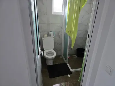 a small bathroom with a toilet and a window at Apartamento Inteiro Porto Novo Abufador in Porto Novo