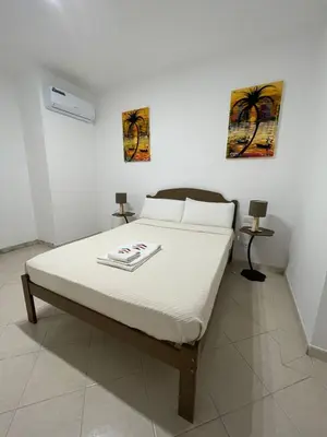 a bed in a bedroom with two pictures on the wall at Larriba Santa Maria by RPG Group in Santa Maria