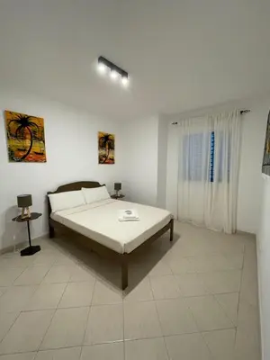 a white bedroom with a bed and a window at Larriba Santa Maria by RPG Group in Santa Maria