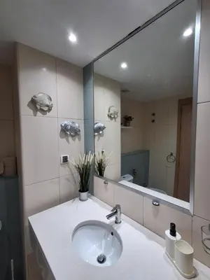 a bathroom with a sink and a large mirror at Vila Verde Ficus in Santa Maria