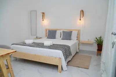 a white bedroom with a large bed with pillows at Comfortable 1-bedroom 400 meters from the beach with Fast Wi-Fi in Santa Maria
