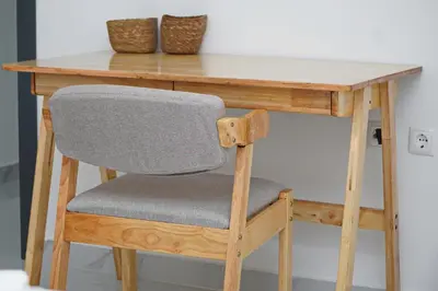 a wooden table with a chair at a desk at Comfortable 1-bedroom 400 meters from the beach with Fast Wi-Fi in Santa Maria