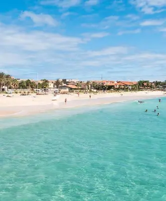 a group of people swimming in the ocean on a beach at Comfortable 1-bedroom 400 meters from the beach with Fast Wi-Fi in Santa Maria
