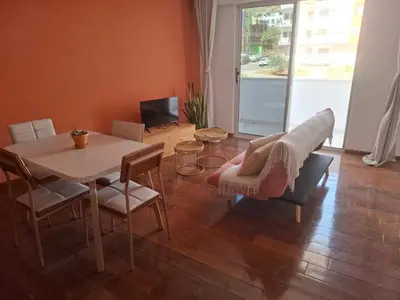 a living room with a table and chairs and a television at Tdois in Praia
