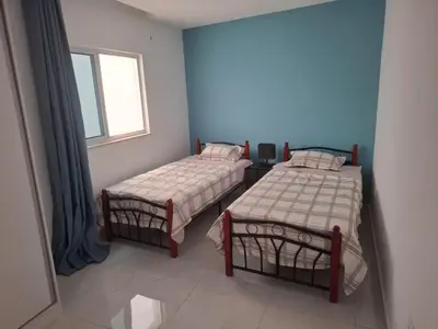 two beds in a room with a window at Tdois in Praia