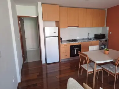 a kitchen with a table and a white refrigerator at Tdois in Praia
