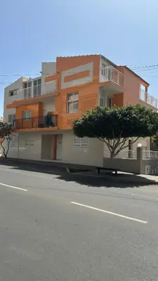 an orange and white building with a tree in front of it at Natflor in Praia