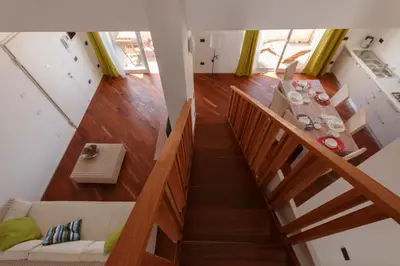 a wooden staircase with a table in a room at Villa ao Mar in Santa Maria