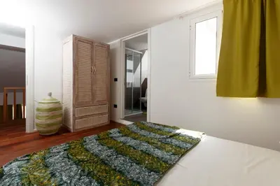 a white bedroom with a bed and a window at Villa ao Mar in Santa Maria