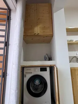 a washing machine in a room with a cabinet at Bounty Apartment Santa Maria by RPG Group in Santa Maria