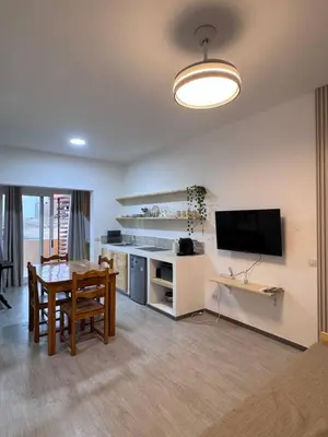 a living room with a table and a desk and a television at Bounty Apartment Santa Maria by RPG Group in Santa Maria