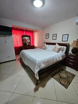 a bedroom with a large bed and a red window at Casa América in Praia