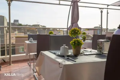 a table with flowers on top of a balcony at Hotel Cesaria in Praia