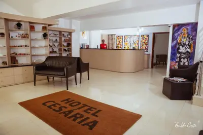a lobby with a hotel station with a rug on the floor at Hotel Cesaria in Praia
