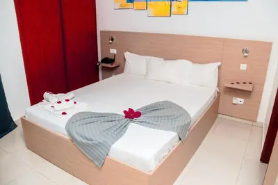 a bedroom with a bed with a red bow on it at Hotel Cesaria in Praia