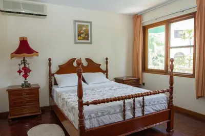 a bedroom with a wooden bed and a window at Arla Residential in Mindelo