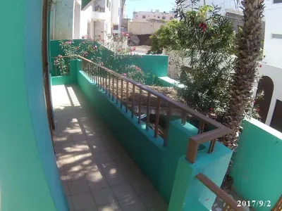 a balcony with blue walls and a wooden railing at Arla Residential in Mindelo