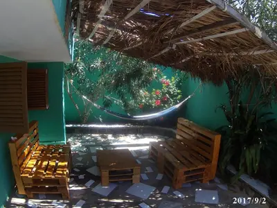 a patio with benches and a hammock in a building at Arla Residential in Mindelo