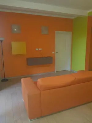 a living room with an orange couch and a white door at Surf House Cabo Verde in Santa Maria