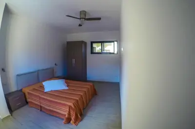 a bedroom with a bed and a ceiling fan at Surf House Cabo Verde in Santa Maria