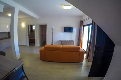 a living room with an orange couch in a room at Surf House Cabo Verde in Santa Maria