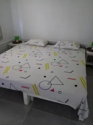 a bed with a white comforter with arrows and numbers on it at Coin de Paradis,Pavillon Doucimar in Porto Novo