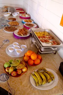 a table with plates of food and fruit on it at Aparthotel Ponta Preta in Santa Maria