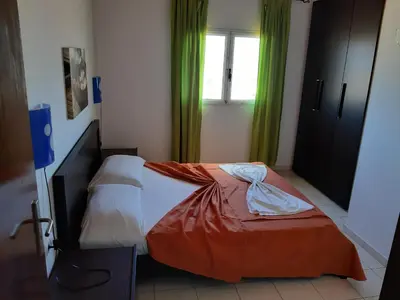 a bed in a room with green curtains at Aparthotel Ponta Preta in Santa Maria