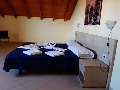 a bedroom with a bed with towels on it at Aparthotel Ponta Preta in Santa Maria