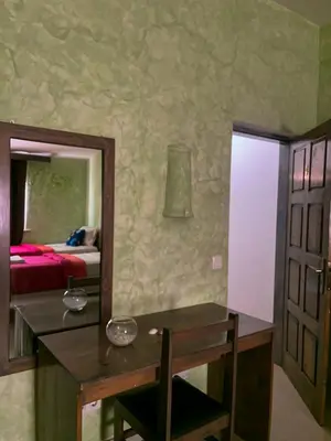 a bathroom with a vanity and a mirror and a bed at Vivenda Viviani in Praia