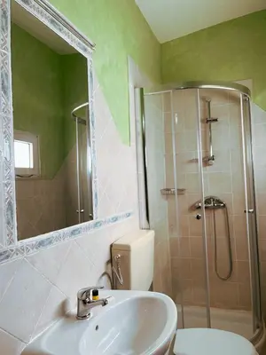 a bathroom with a sink and a shower and a toilet at Vivenda Viviani in Praia