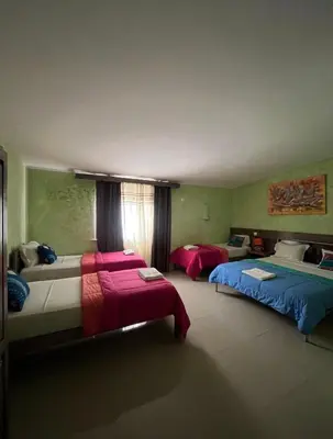 a room with two beds and two tables in it at Vivenda Viviani in Praia