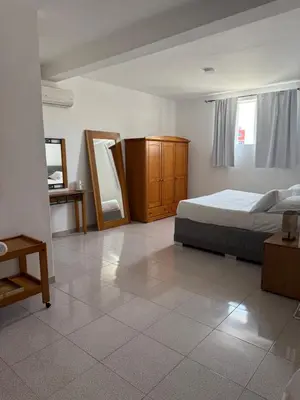 a bedroom with a bed and a dresser and a mirror at Pousada Praia Maria in Praia