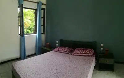 a bedroom with a bed with pink sheets and a window at Aldeia Jerome in Paul