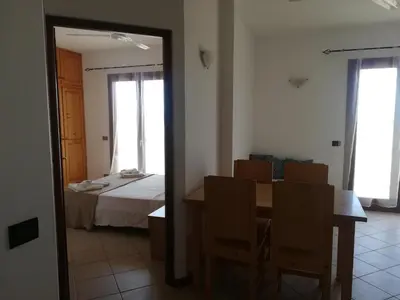 a room with a table and a bed and a mirror at Pedra do Sol Praia Estoril Sal Rei FREE WI-FI in Sal Rei