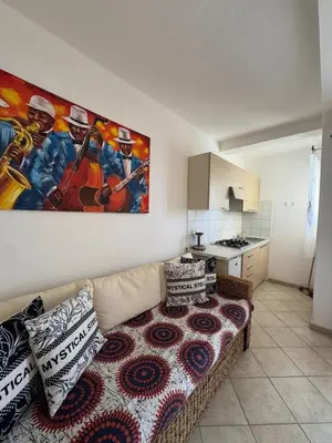 a living room with a couch and a kitchen at Holiday Properties Tres Caravelas in Santa Maria