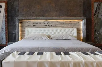 a bedroom with a large white bed with a wooden headboard at Ocean Suites in Santa Maria