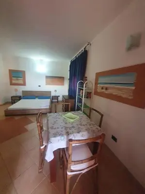 a room with a table and a bedroom with a bed at Holiday Properties Oleandro Ocean in Santa Maria