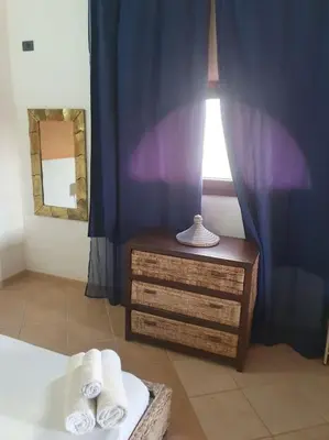 a bedroom with a bed and a dresser and a window at Holiday Properties Oleandro Ocean in Santa Maria