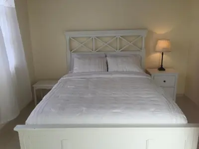 a large white bed with two tables and a lamp at Hotel Cruz Grande-Brava in Vila Nova Sintra
