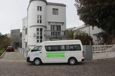 a white van parked in front of a white building at Hotel Cruz Grande-Brava in Vila Nova Sintra
