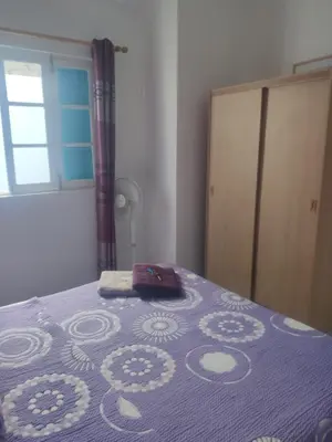 a bedroom with a bed with a purple blanket at Maderalzinho in Mindelo