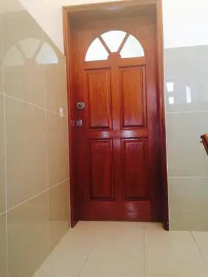 a wooden door in a bathroom with a shower at Maderalzinho in Mindelo