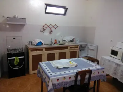 a kitchen with a table and a sink and a stove at Damontanha in Ribeira Grande