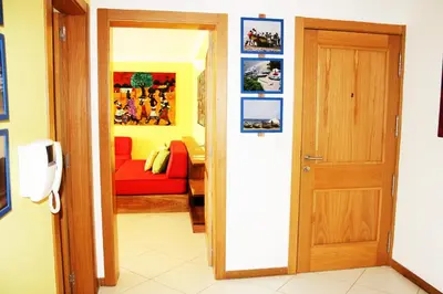 a door leading into a living room with a red couch at Suite Mariposa Sospesa Sul Mare in Mindelo